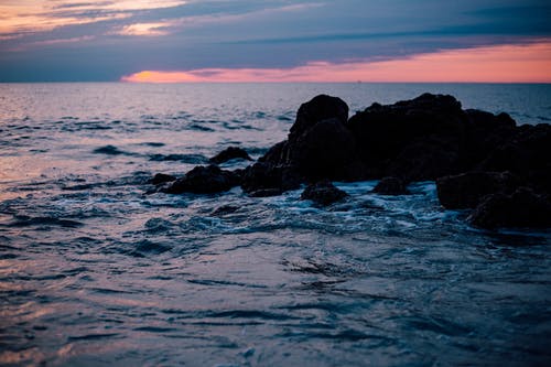 太阳落山时的岩石海岸 · 免费素材图片