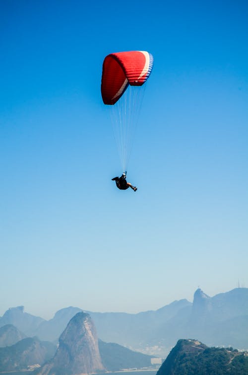 白天在山顶上的红白色降落伞 · 免费素材图片