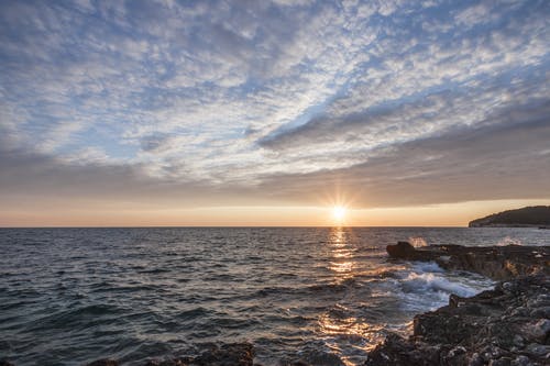 夕阳下海边的黑岩 · 免费素材图片