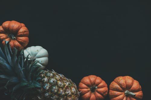 两个南瓜附近的菠萝果实的摄影 · 免费素材图片