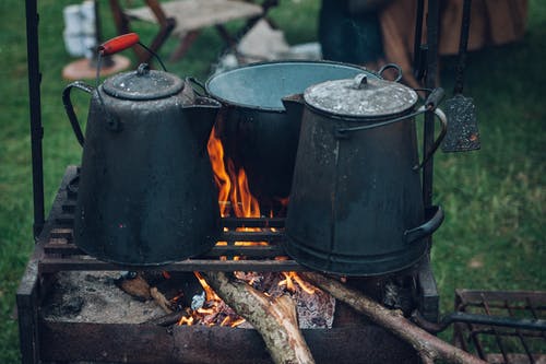 在烧烤的三个黑色和灰色锅与焦点照片上的火 · 免费素材图片