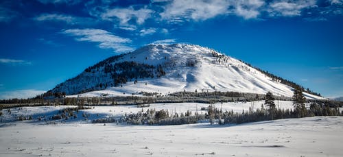 多云的天空下的冰雪覆盖的山 · 免费素材图片