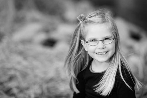 女孩微笑的灰度摄影 · 免费素材图片