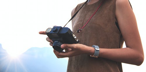 女人拿着相机在山附近 · 免费素材图片