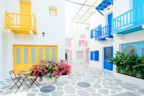 三栋粉红色，蓝色和黄色建筑物的建筑摄影 · 免费素材图片