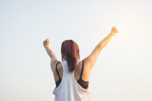 女人穿着黑色胸罩和白色背心提高双手放在顶部 · 免费素材图片