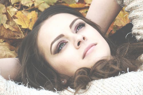 躺在枯萎的叶子上的女人 · 免费素材图片