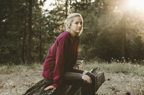 女人坐在漂移木 · 免费素材图片