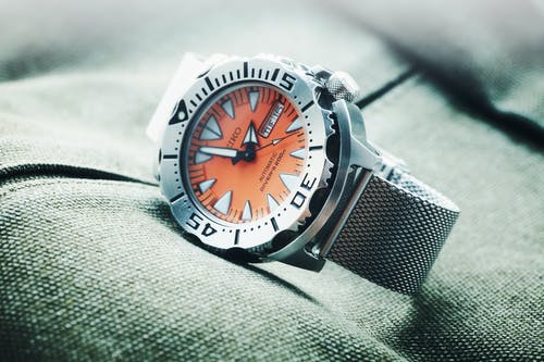 圆形橙色和银色精工模拟手表，显示1:57 · 免费素材图片