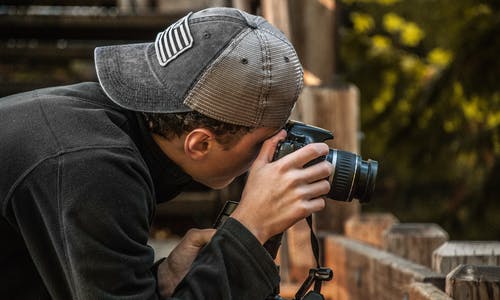 男子手持单反相机的景深摄影 · 免费素材图片