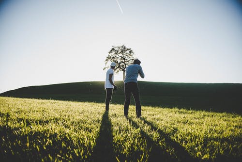 两名男子站在绿色的草地上 · 免费素材图片