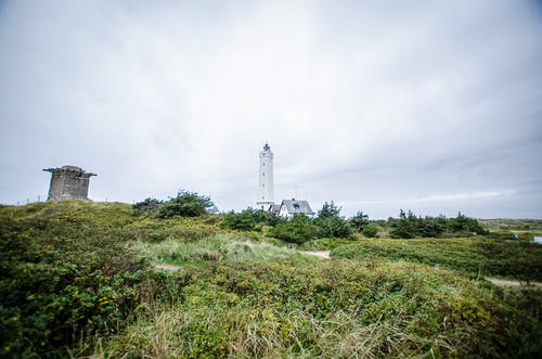 在绿色的田野背景下的白色灯塔 · 免费素材图片