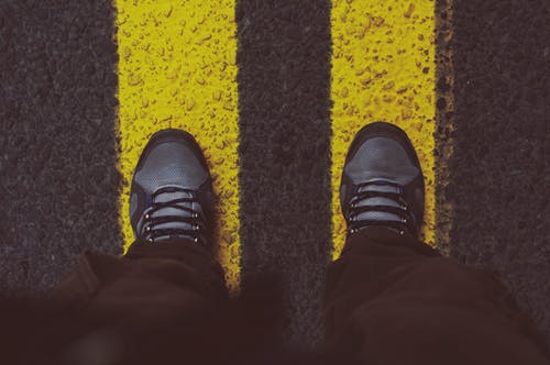站在人行道上的灰色运动鞋的人 · 免费素材图片