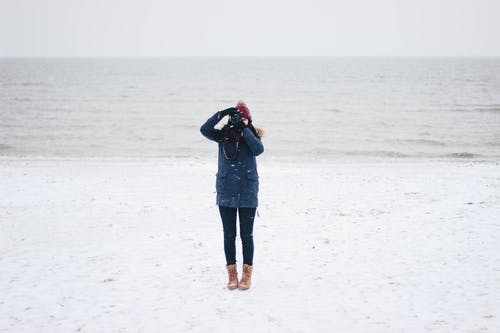 女人在海滩上拍照 · 免费素材图片