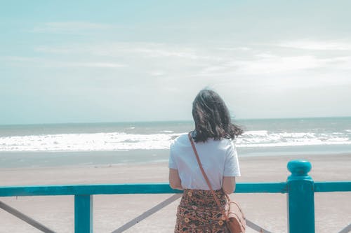 女人站在海边附近 · 免费素材图片