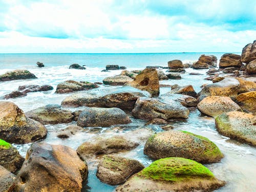 苔藓被水包围的岩石的风景摄影 · 免费素材图片