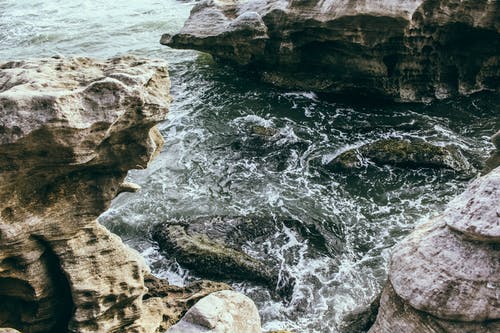 水体附近的棕色岩层 · 免费素材图片