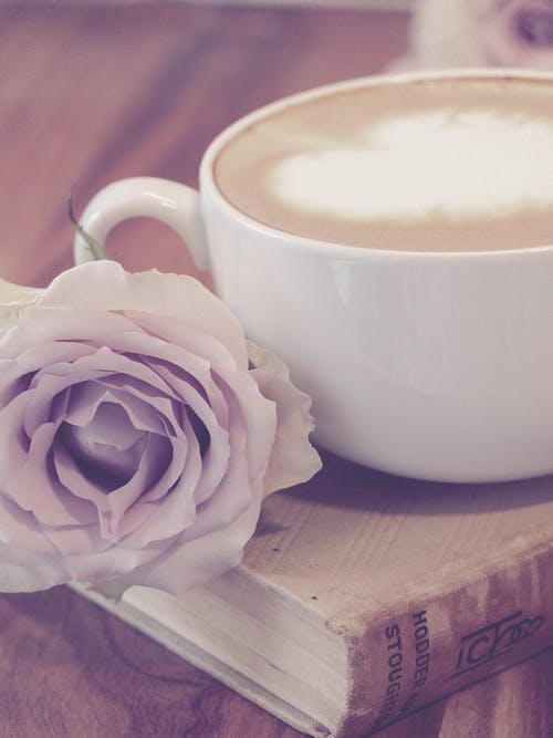 在书旁的咖啡旁边的花的摄影 · 免费素材图片