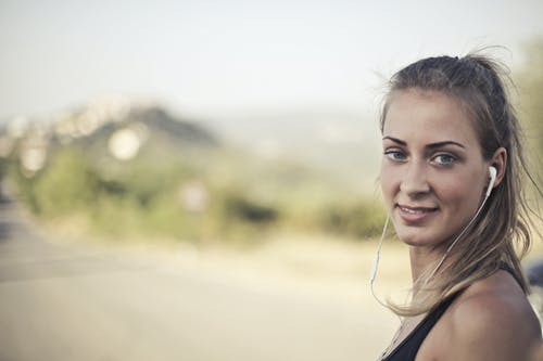 女人穿着黑色背心和白色耳塞 · 免费素材图片