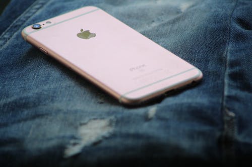 玫瑰金iphone 6s在蓝色牛仔牛仔裤上的特写摄影 · 免费素材图片