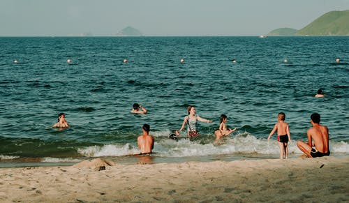 人们在沙滩上游泳的摄影 · 免费素材图片