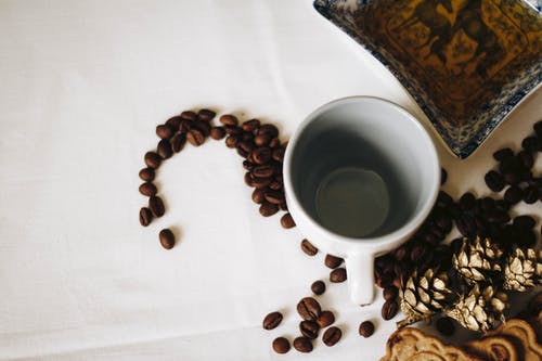 白色陶瓷杯附近的棕色咖啡豆 · 免费素材图片