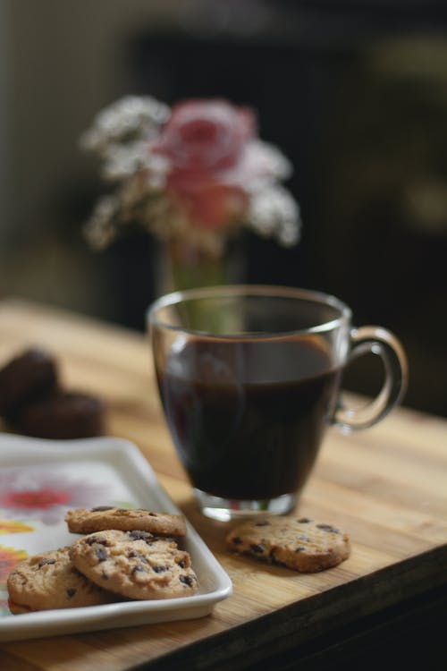 桌上的托盘上的饼干旁边的玻璃茶杯 · 免费素材图片