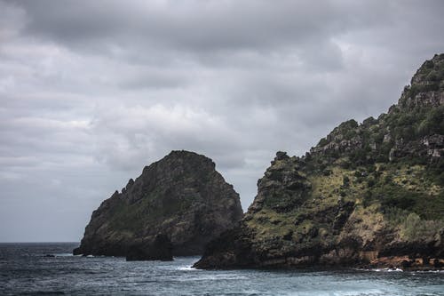 乌云下水体的棕色岩层 · 免费素材图片