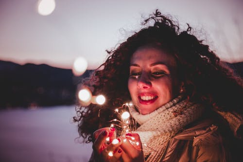 女人抱着白色的灯串 · 免费素材图片