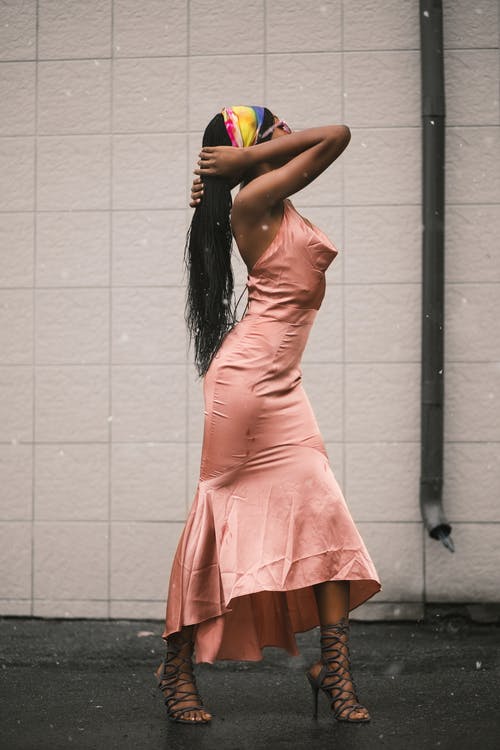 粉红色的裙子举行头发的女人 · 免费素材图片