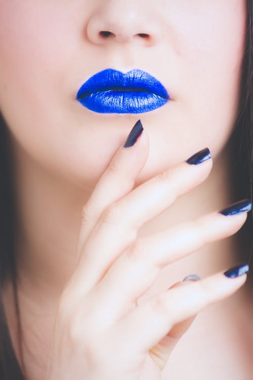 女人穿着蓝色的唇膏和修指甲 · 免费素材图片