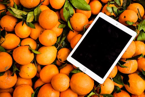 Ipad在橙色水果上的照片 · 免费素材图片