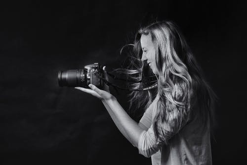 女人使用单反相机的灰度照片 · 免费素材图片