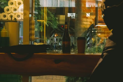 桌上的独奏杯旁边的啤酒瓶 · 免费素材图片