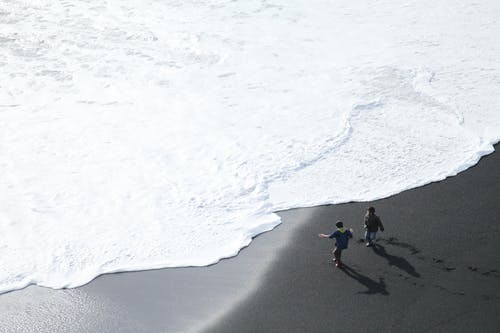 海滩上的两个人 · 免费素材图片