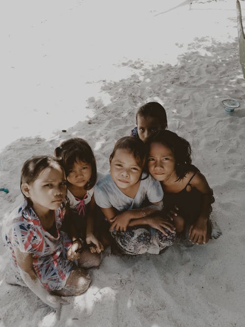 五个小孩坐在沙滩上 · 免费素材图片