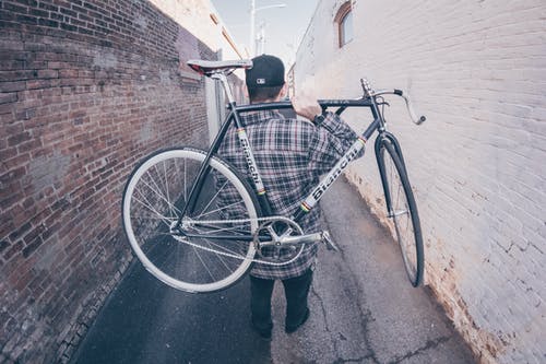 男子携带白色和黑色的bianchi公路自行车 · 免费素材图片
