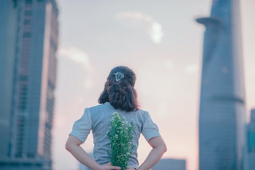 女人拿着白花的摄影 · 免费素材图片