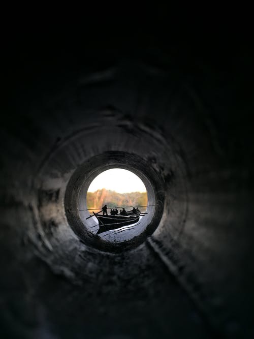 人们骑着独木舟船从管道内查看 · 免费素材图片