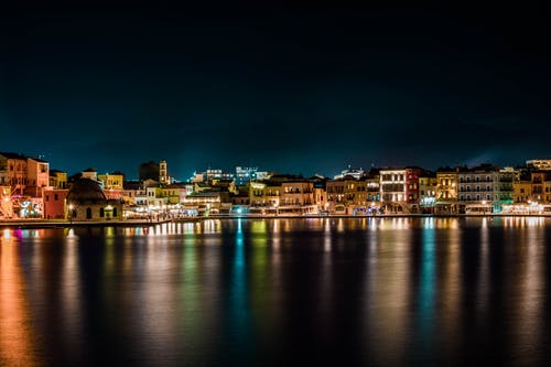 夜间水域附近的城市景观 · 免费素材图片