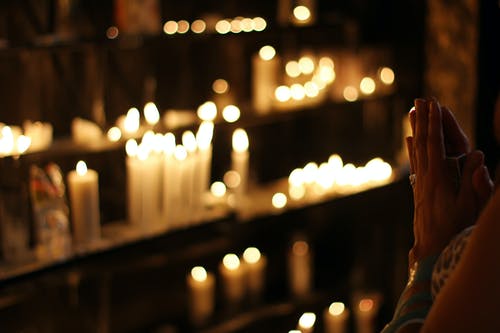 关闭在前排蜡烛祈祷的人的照片 · 免费素材图片