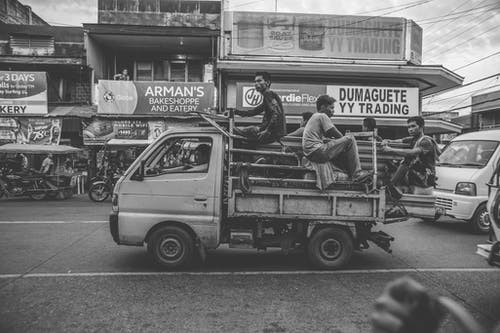 男子骑在kei卡车上的灰度照片 · 免费素材图片