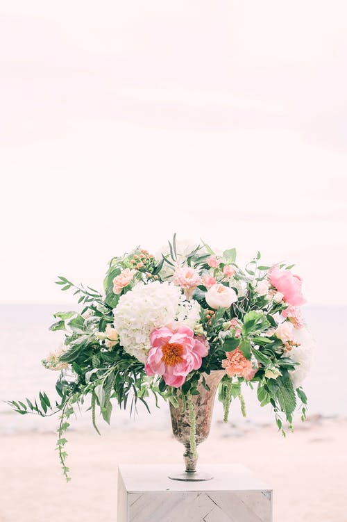 灰色花瓶上的白色和粉红色的花朵的照片 · 免费素材图片