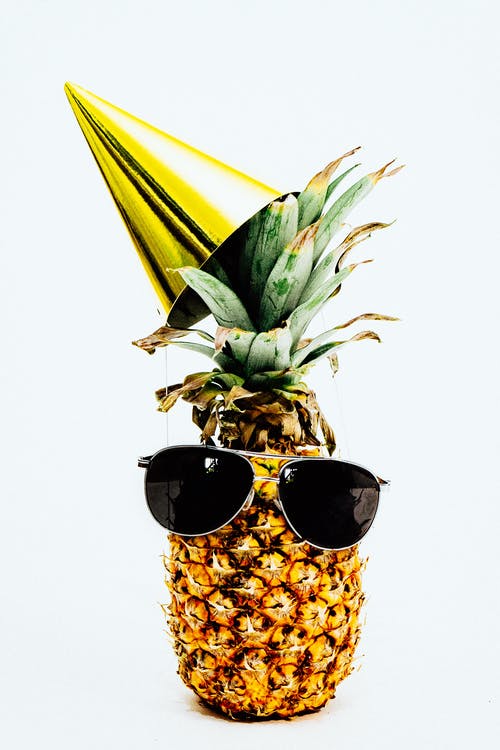 菠萝戴着黑色飞行员风格太阳镜和派对帽的照片 · 免费素材图片