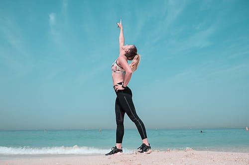 女人指着海边的天空 · 免费素材图片