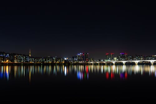 夜间水域附近的城市 · 免费素材图片