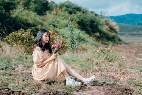米色的裙子和白色的鞋子，坐在绿色草地上的女人 · 免费素材图片