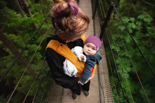 桥上的女人抱着婴儿 · 免费素材图片