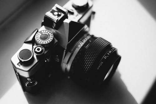 白色表面上的黑色和灰色dslr相机 · 免费素材图片