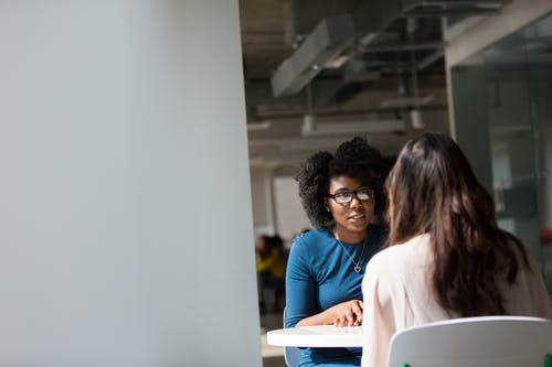 女人穿着桌子旁边的蓝色上衣 · 免费素材图片